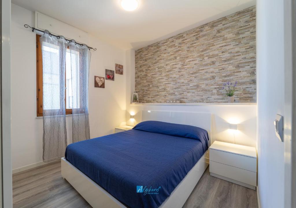 una camera da letto con un letto e un muro di mattoni di Mica apt ad Alghero