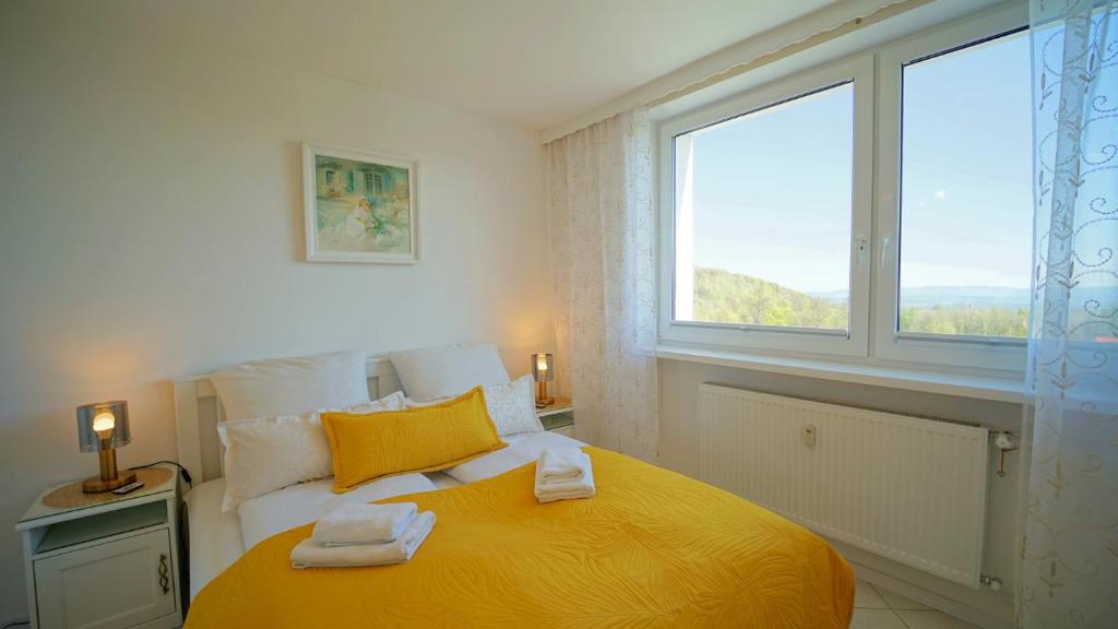 een slaapkamer met een geel bed en 2 handdoeken erop bij Apartamenty Every Sky Nadrzeczna 14 Karpacz in Karpacz