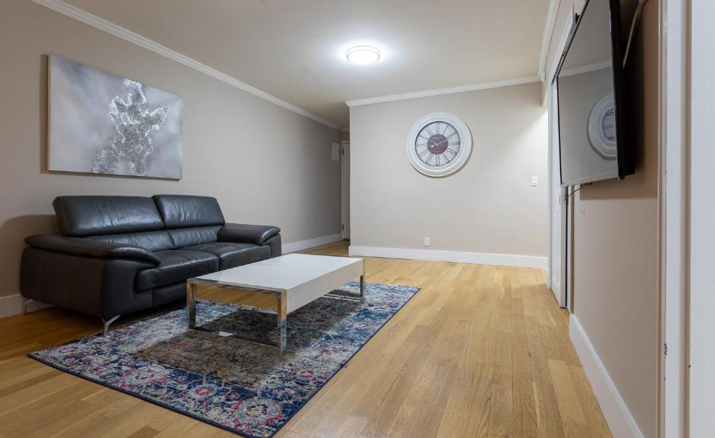 uma sala de estar com um sofá de couro preto e uma mesa em Lovely 3 BR in NYC with Elevator em Nova York