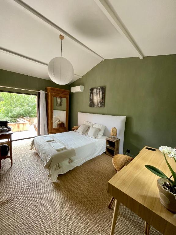 une chambre avec un grand lit et une table dans l'établissement Beauregard Cévennes - Sublime chambre d'hôtes indépendante et moderne, à Monoblet