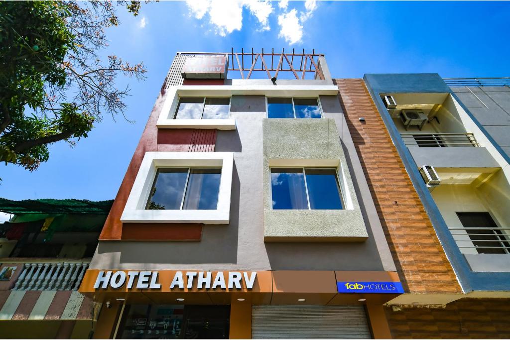 インドールにあるFabHotel Atharvのホテルのアトショーサインが貼られた建物