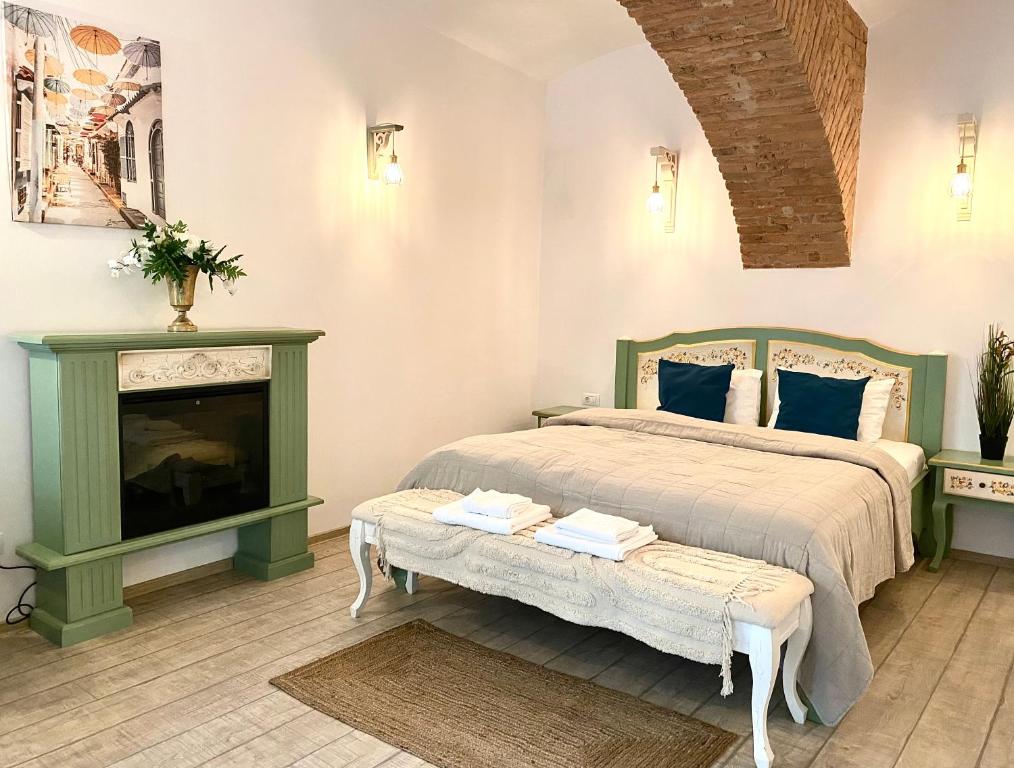 a bedroom with a bed and a fireplace at Republique Apartment in Braşov