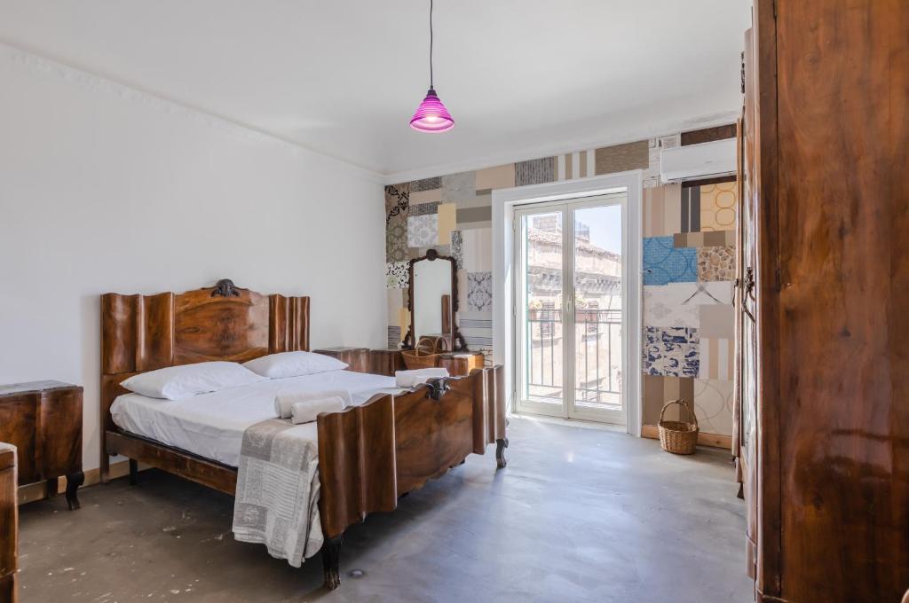 a bedroom with a large bed with a wooden frame at Ballarò Market Street Art Stylish Flat x10 in Palermo
