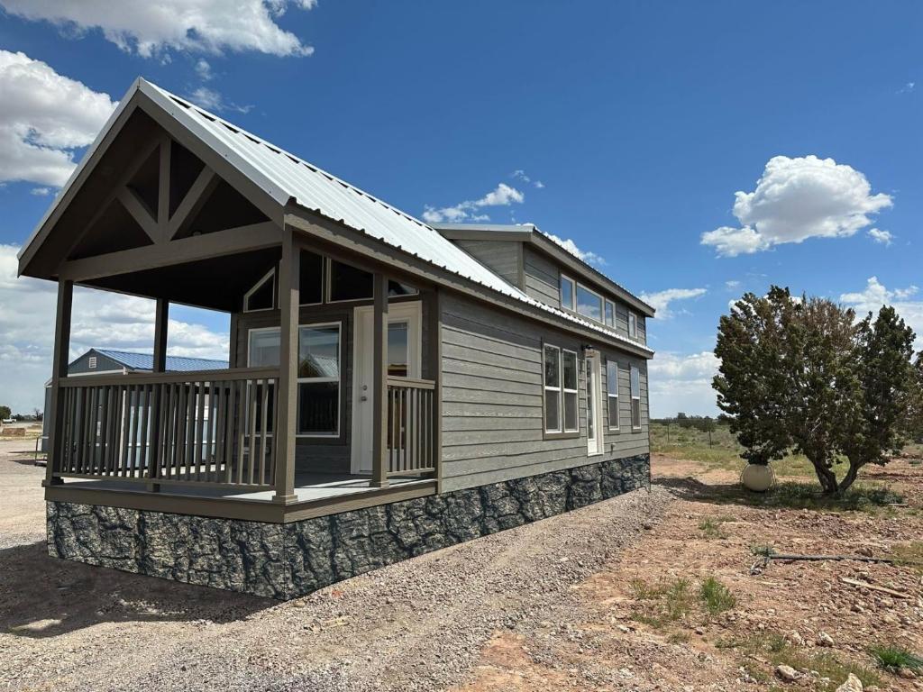 a small house with a porch on a gravel road at 081 Tiny Home nr Grand Canyon South Rim Sleeps 8 in Valle