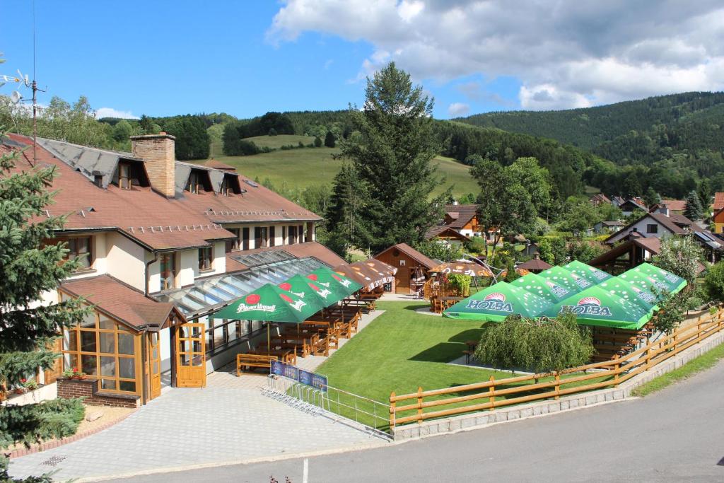 Hotel STARÝ MLÝN في جيسينيك: اطلالة جوية على مبنى فيه مظلات خضراء