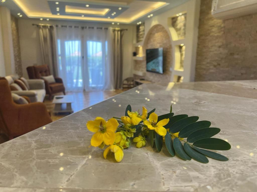 un bouquet de fleurs jaunes assises sur un comptoir dans l'établissement Villa Front Beach First row family only, à Ain Sokhna