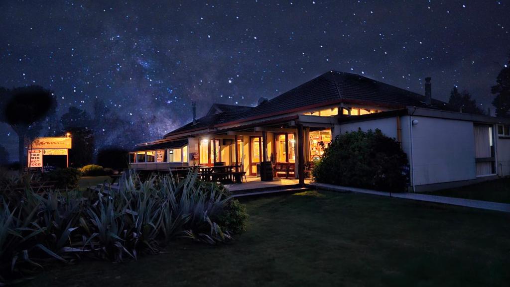een huis 's nachts met een sterrenhemel bij Manapouri Lakeview Motor Inn in Manapouri
