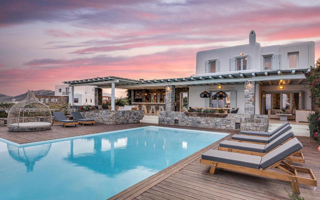 a villa with a swimming pool and a house at El Sueno Villa Mykonos in Kalafatis