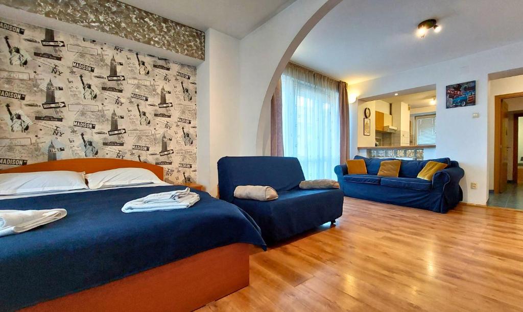 a bedroom with a bed and two blue chairs at Comfy&Bright 2BD Family-Friendly APT Amazing View in Bucharest