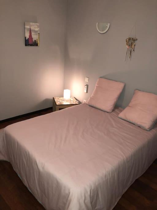 a bedroom with a white bed with two pillows and a table at T2 LA CIOTAT 60M2 AVEC TERRASSE EQUIPÉE in La Ciotat