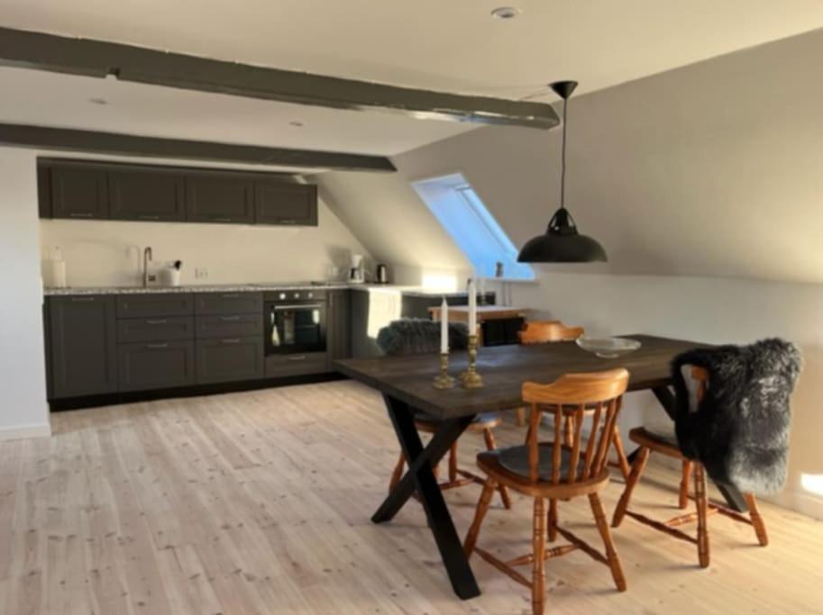 una cucina con tavolo e sedie in una stanza di Unik ferielejlighed i Marstal. a Marstal