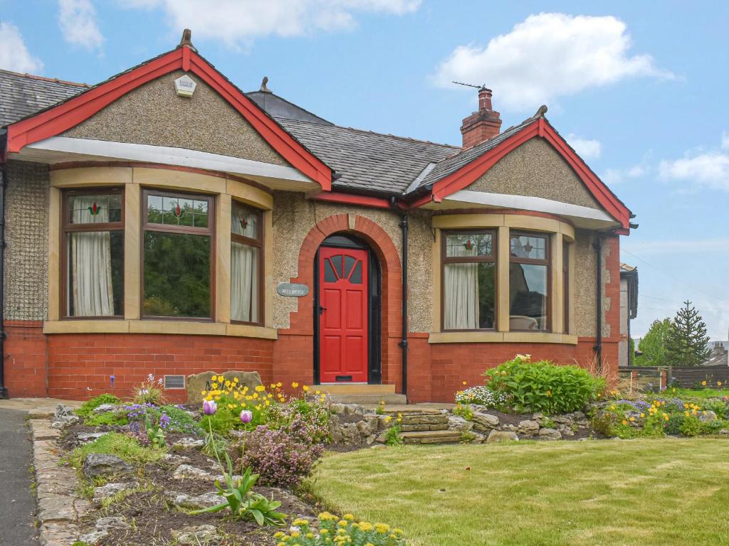ein Haus mit einer roten Tür und einem Hof in der Unterkunft Melrose in Clitheroe