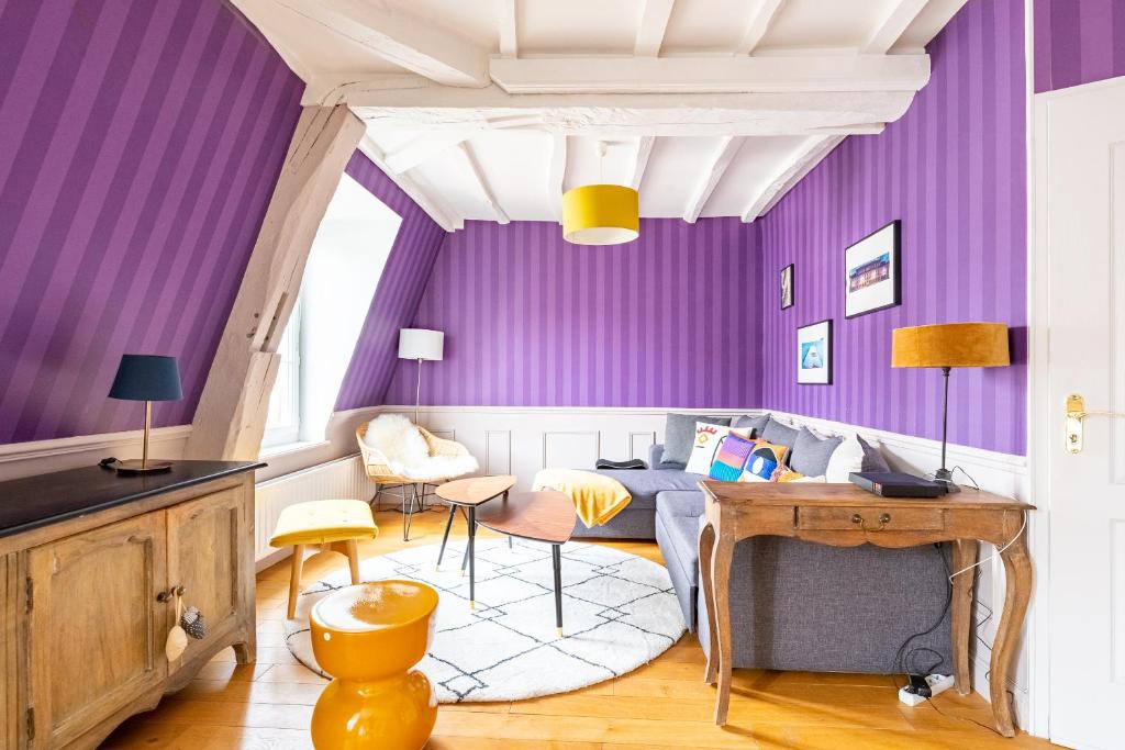 uma sala de estar com paredes roxas e um sofá em Le Lilas - Hypercentre Confort Calme 4 voyageurs em Dijon