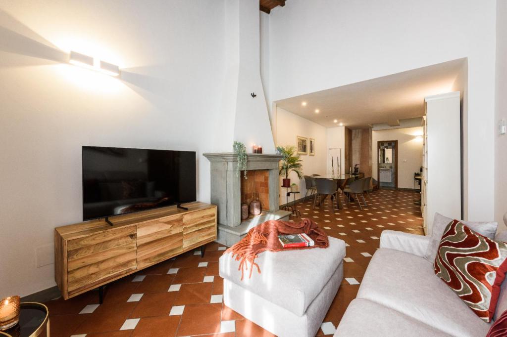 uma sala de estar com uma televisão de ecrã plano e um sofá em Apartments Florence- Faenza Terrace em Florença