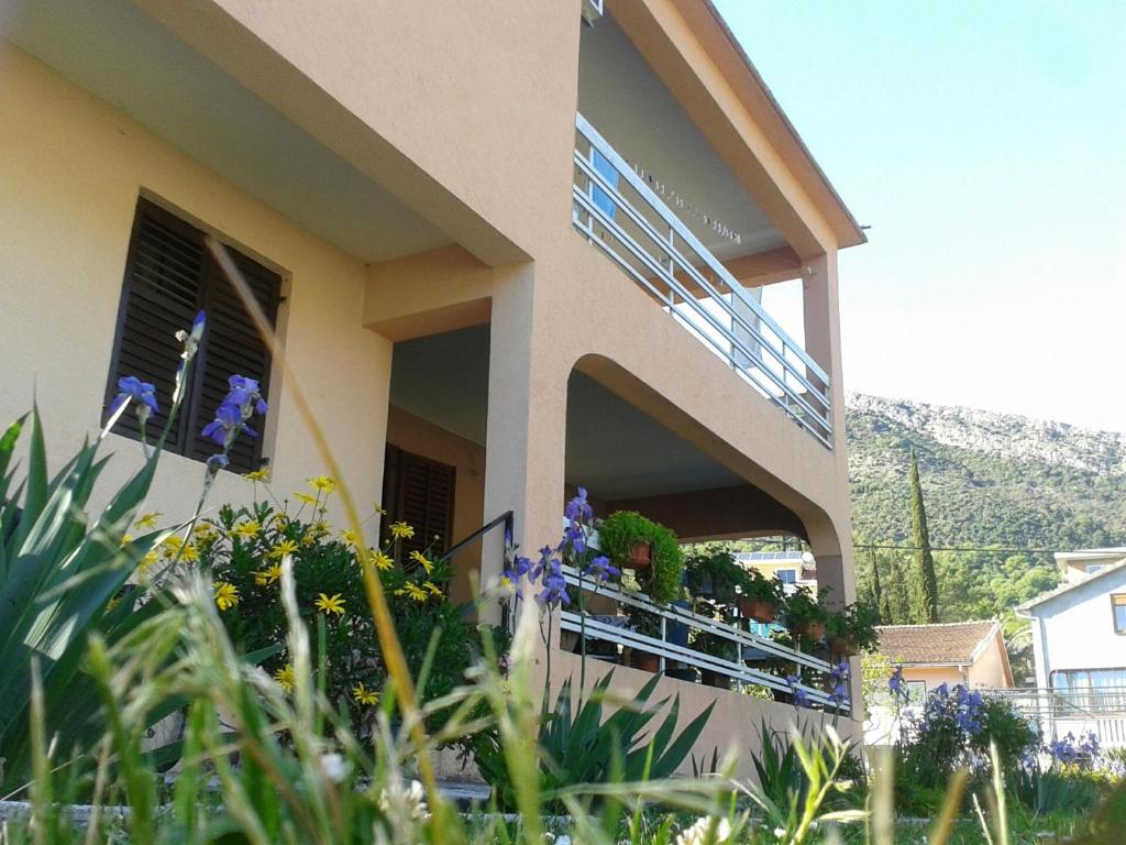 a house with a balcony with flowers on it at Apartment Davidovic in Tivat