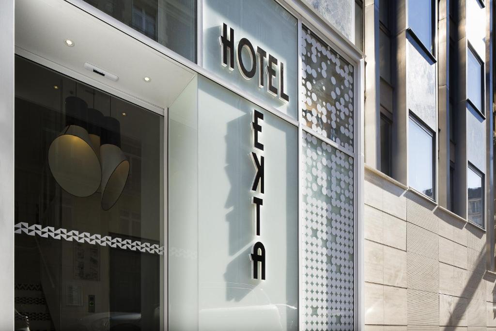a store front with a hotel sign on the side of a building at Hotel Ekta Champs Elysées in Paris