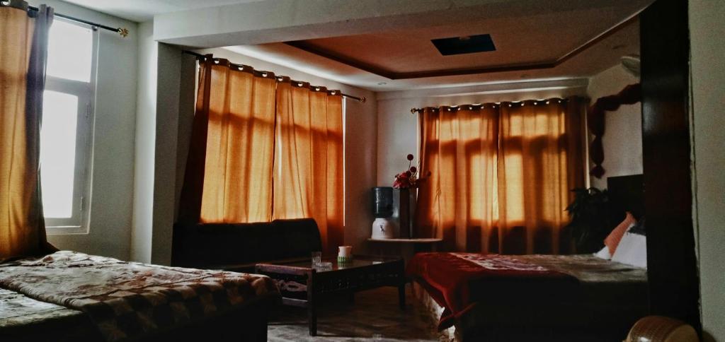 Una habitación de hotel con dos camas y una ventana. en Saspolo chain of G house, en Skardu