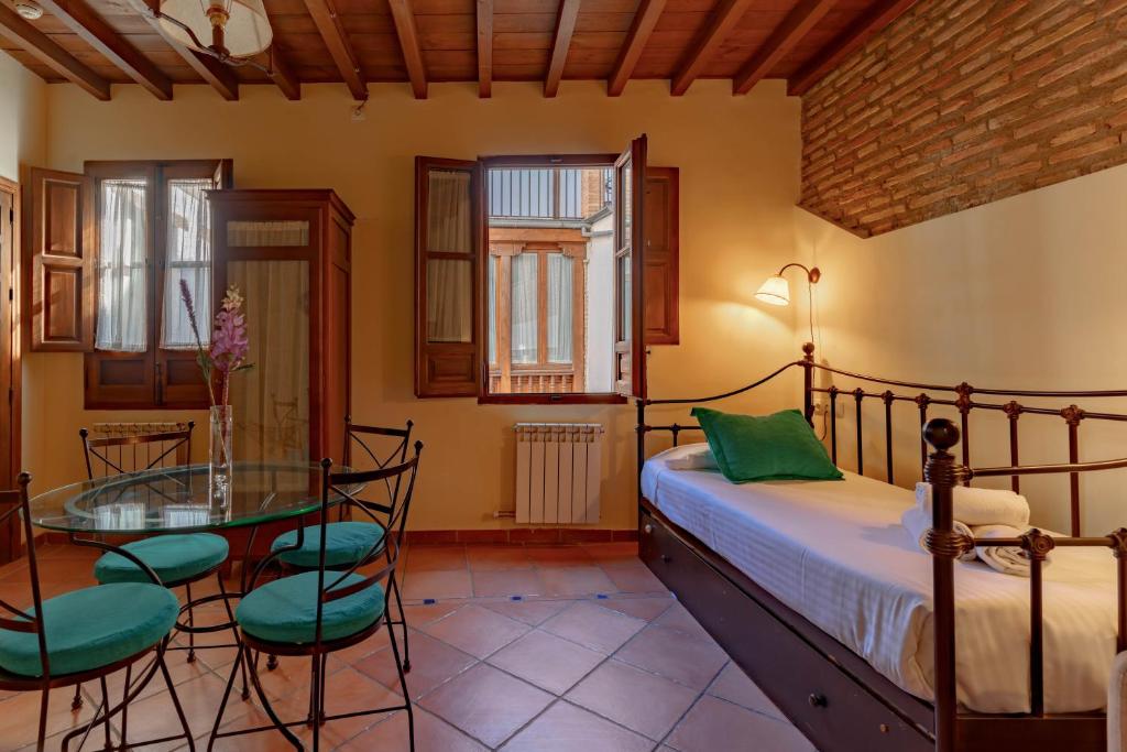 a bedroom with a bed and a glass table and chairs at Charminghomesgranada Apartamento Fajalauza in Granada