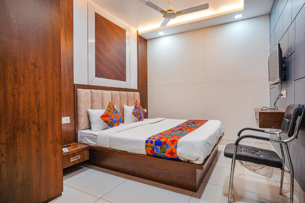 ein Schlafzimmer mit einem Bett und einem TV in der Unterkunft FabHotel Coral in Indore