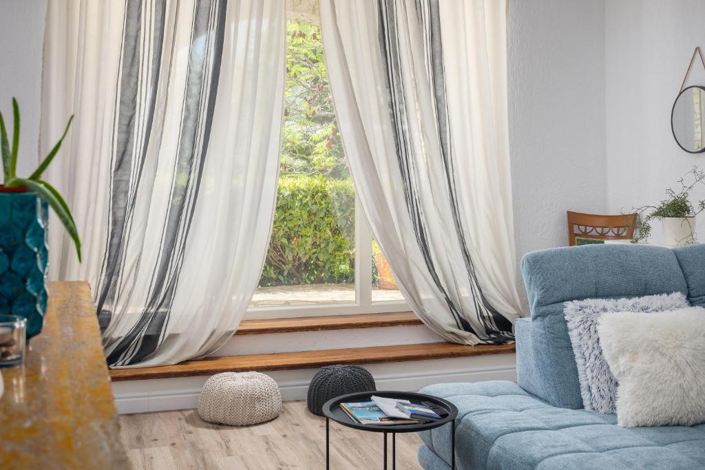 sala de estar con sofá azul y ventana en Family Vacation Villa, en Žbandaj