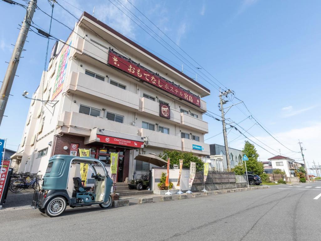 un pequeño coche aparcado frente a un edificio en Omotenashi Hostel Miyajima en Hatsukaichi