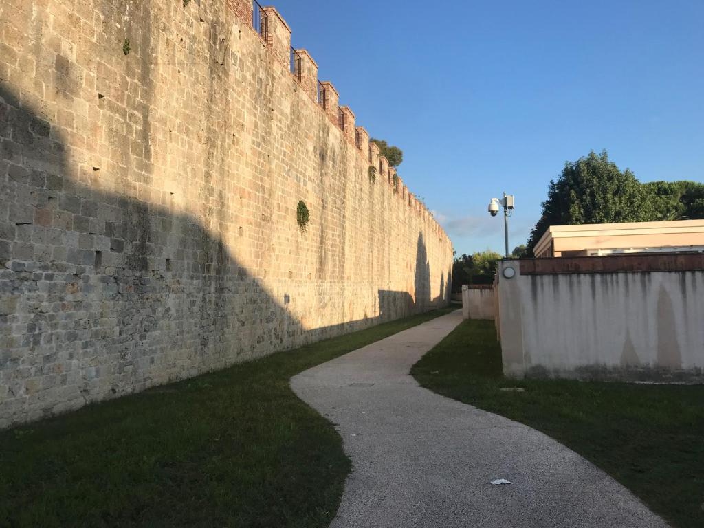 een grote bakstenen muur met een stoep ernaast bij Casa Centrale in Pisa