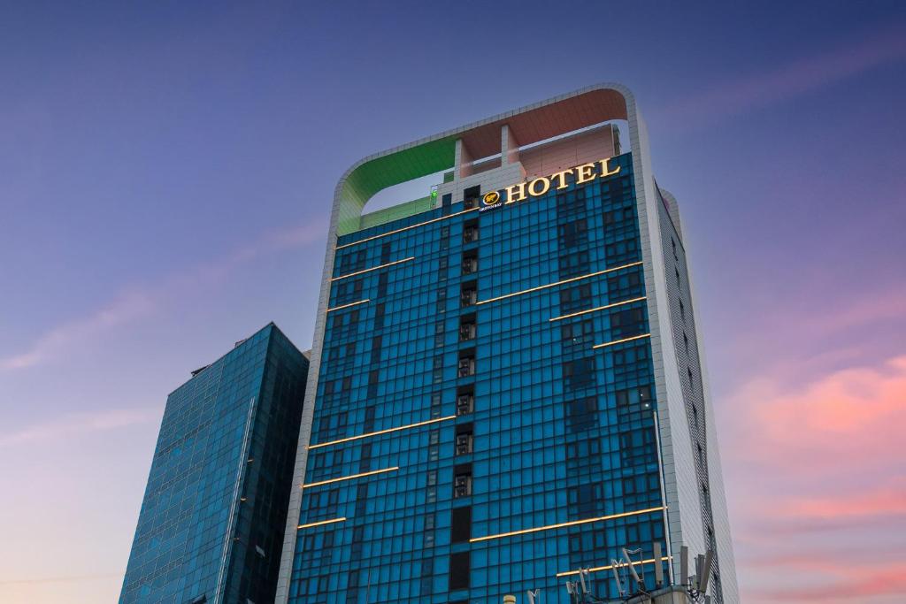 a tall building with a sign on the top of it at Griffinbay Hotel in Busan