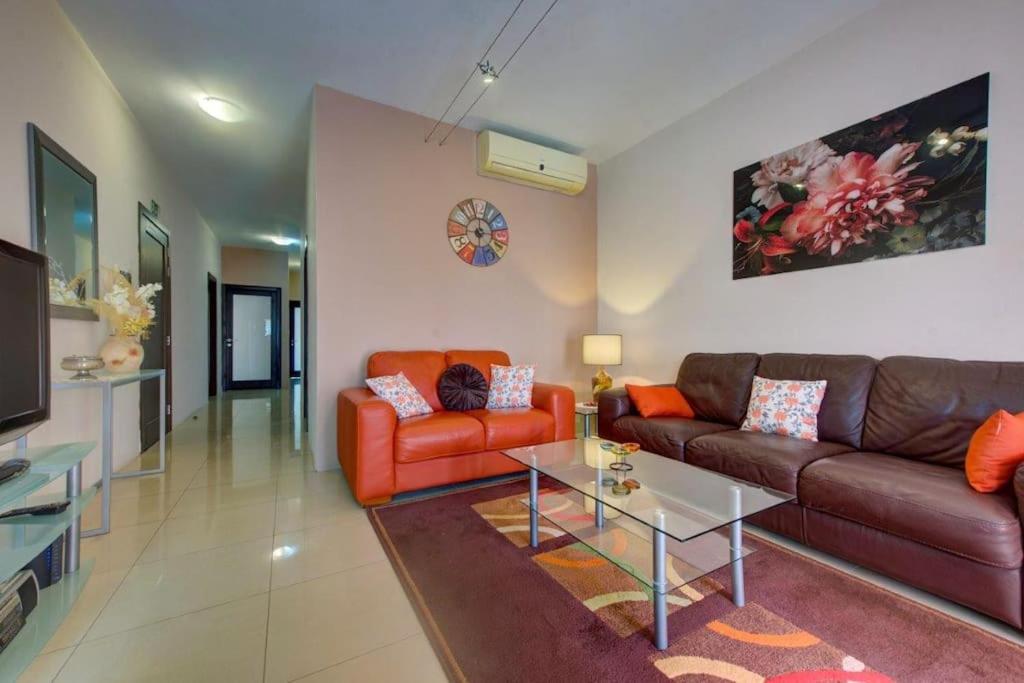 a living room with two couches and a coffee table at Steps from the Sea, Side Sea-View, 3BR Sleep 6 in St. Paul's Bay