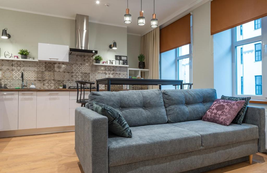 a living room with a couch and a kitchen at Friends and Family Vacation Apartments in Rīga