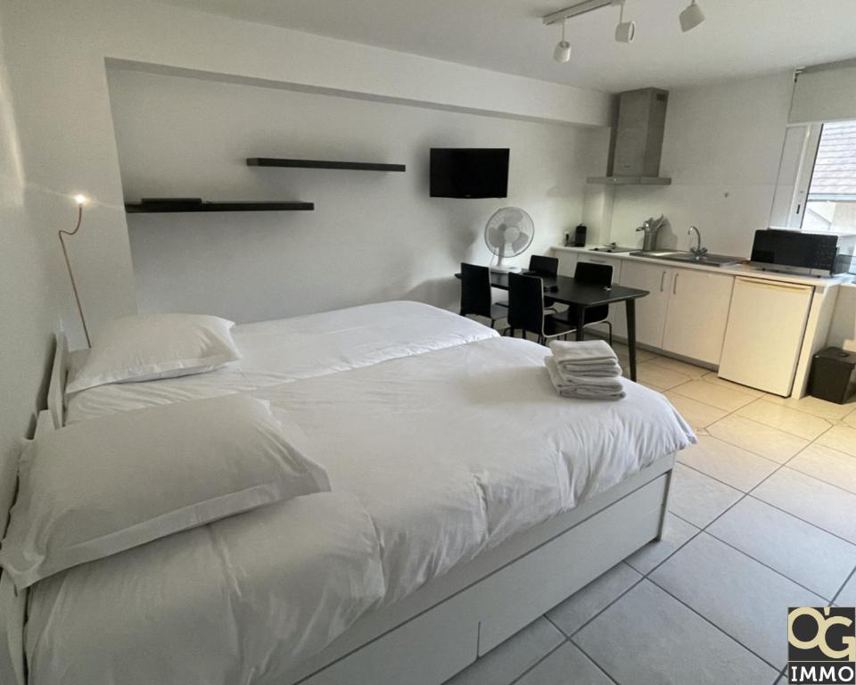 una camera con un grande letto bianco e una cucina di Petit Lac a Duingt