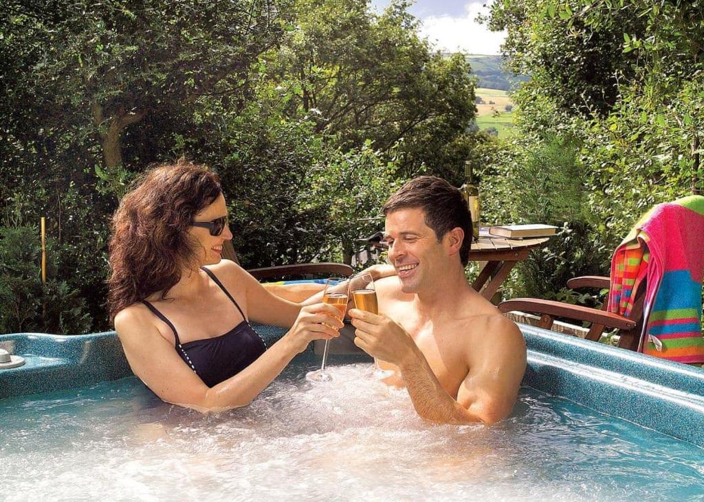 a man and a woman sitting in a swimming pool at Springwood Lodges in Harrogate