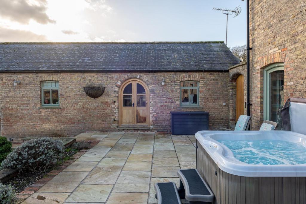 a hot tub in the backyard of a house at The Hideaway - Luxury Cottages in York