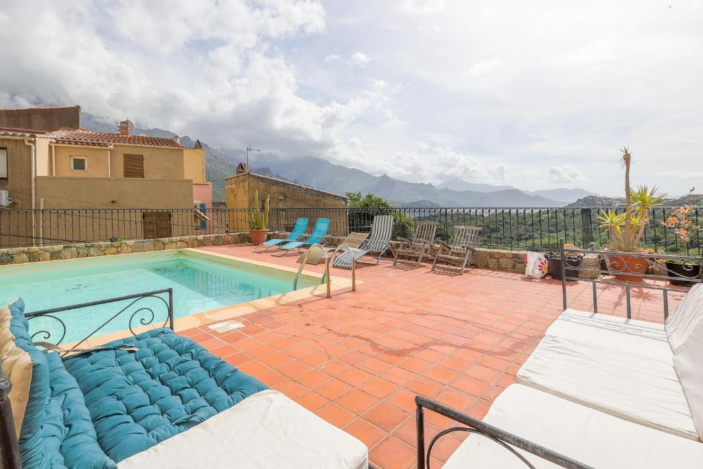 a swimming pool with blue chairs at Casa Pietra - Piscine privative et toit terrasse in Montegrosso