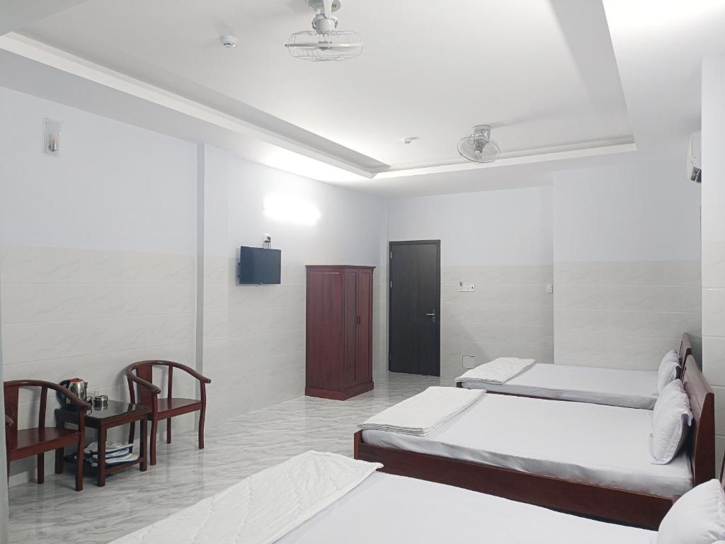 - une chambre avec 2 lits, un bureau et une télévision dans l'établissement KHÁCH SẠN VĂN KHANG, à Bạc Liêu