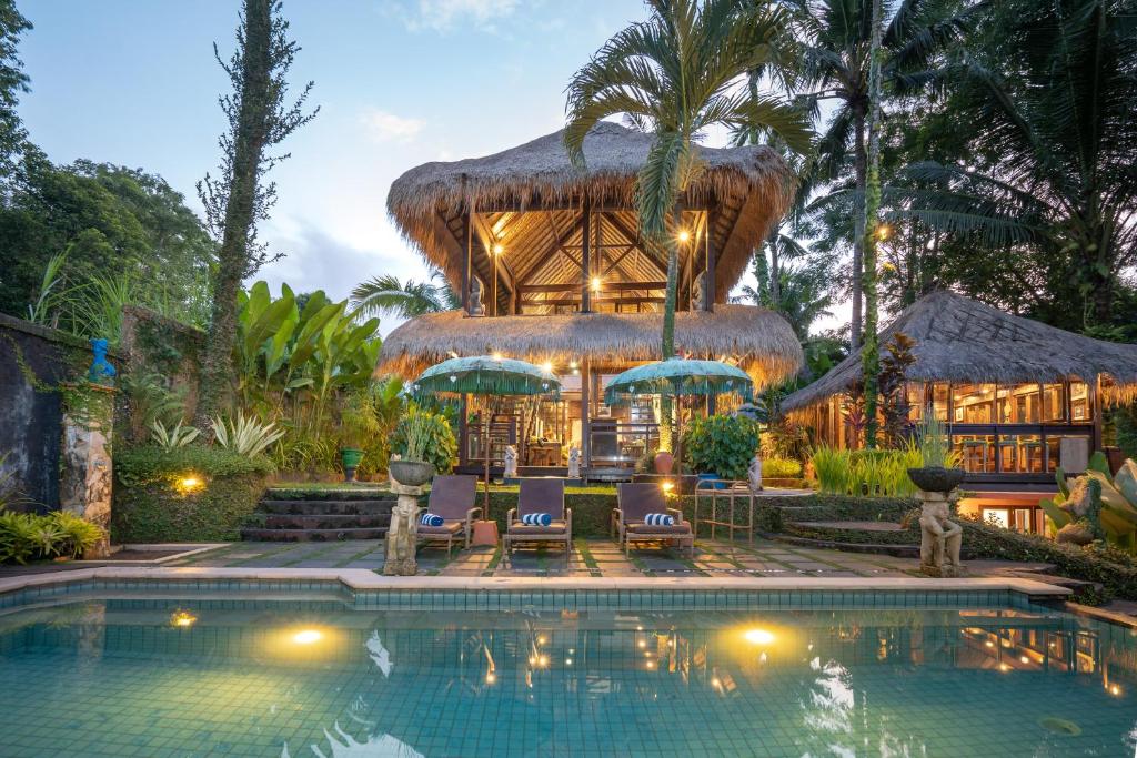 a resort with a swimming pool in front of a building at Kupu Kupu Private Villa in Ubud