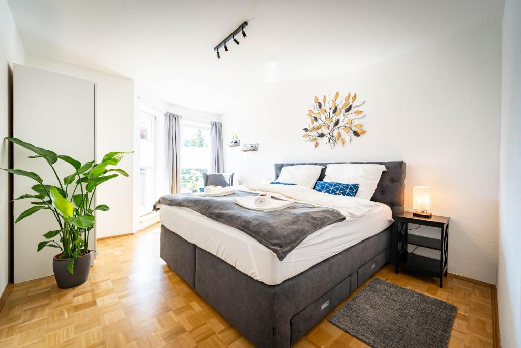 - une chambre avec un lit et une plante en pot dans l'établissement APARTMENTO Magdeburg - Zentral - 2 Zimmer - WiFi - Netflix, à Magdebourg