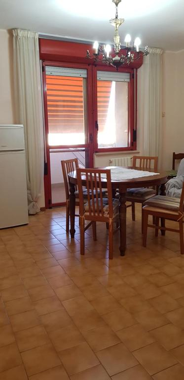 a dining room with a table and chairs and a kitchen at appartamento a 700 mt. dal mare. in Terracina