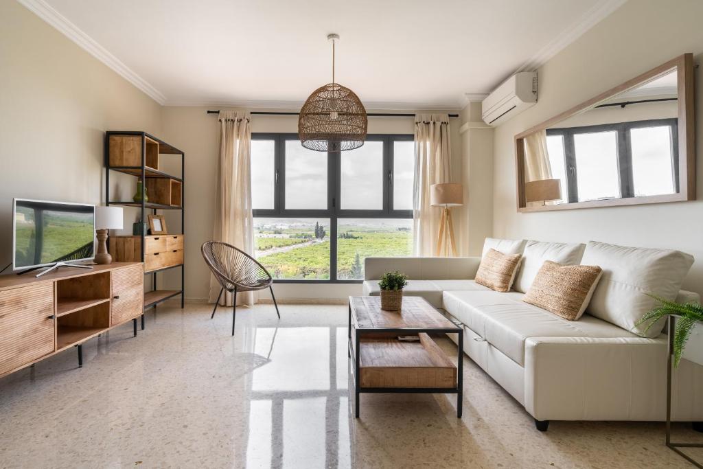 sala de estar con sofá blanco y TV en Magnifico apartamento en Canet Playa by Hometels, en Canet de Berenguer