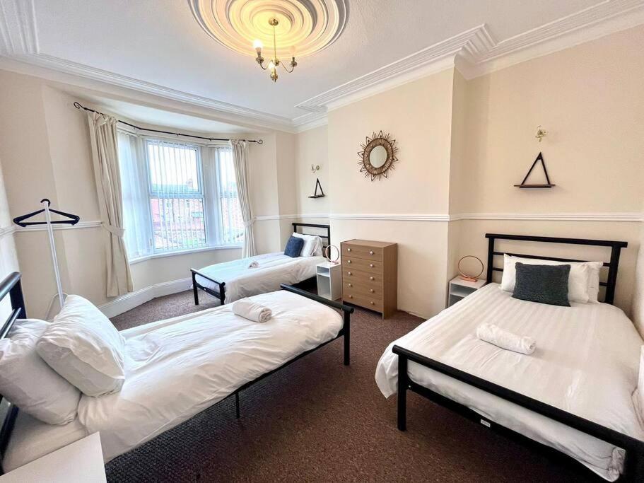 ein Schlafzimmer mit 2 Betten und einem Tisch darin in der Unterkunft The 3 Bedroom Home in Gateshead