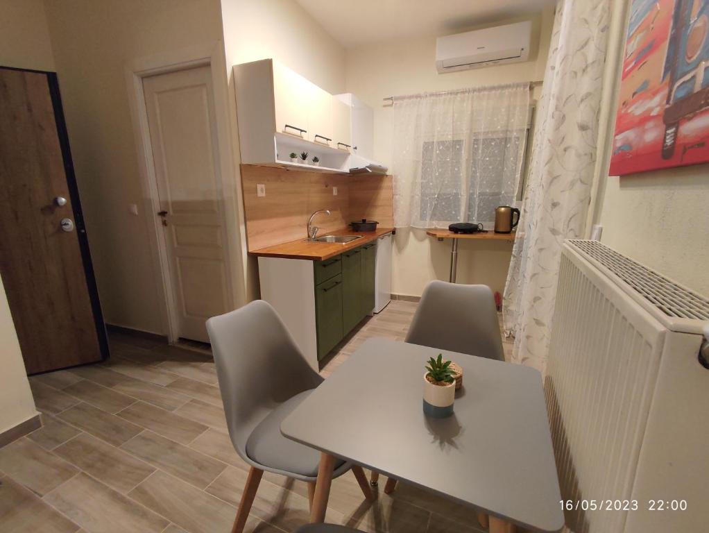 uma pequena cozinha com uma mesa branca e cadeiras em Olivia Studios - Melina's home near the sea em Hagia Triada
