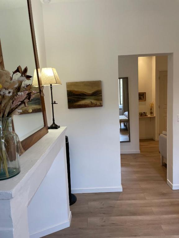 a living room with a table with a lamp and a mirror at La Maison du Clocher in Saint-Émilion