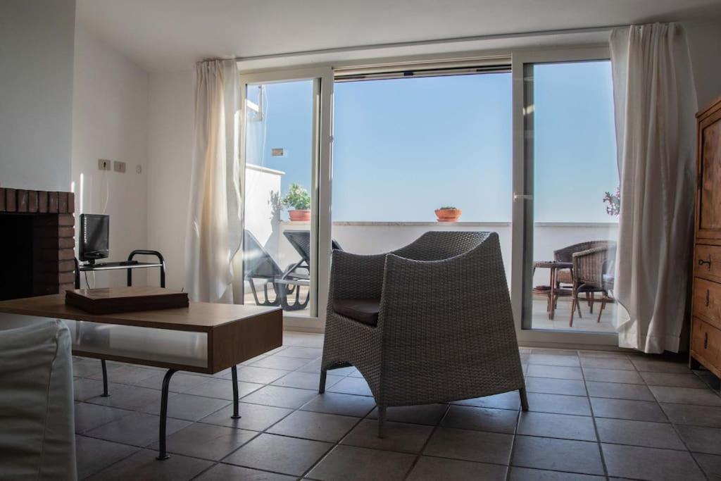 un soggiorno con tavolo e sedie e un balcone di Chiaro di Luna - Appartamento vista mare a Pisciotta