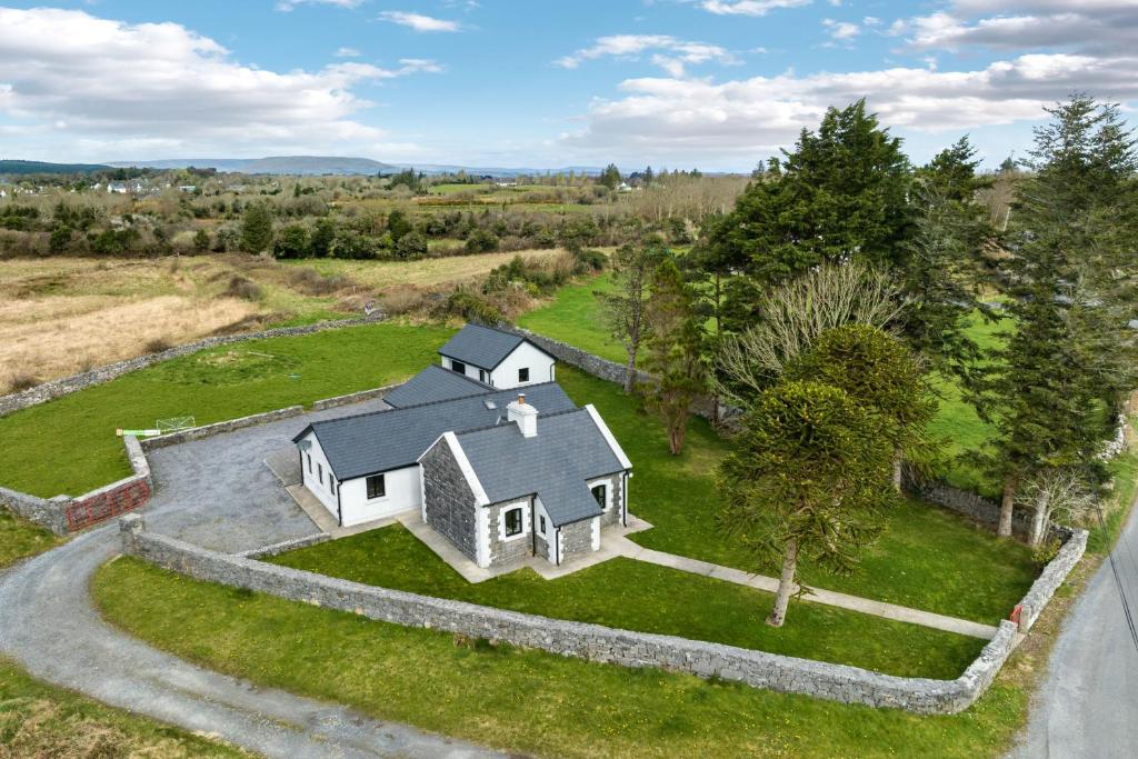 an aerial view of a white house on a green field at Cottage 345 - Oughterard in Oughterard