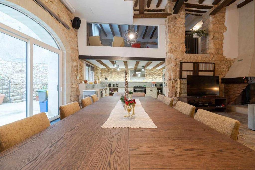 Habitación grande con una larga mesa de madera con sillas. en Casa de ensueño en Almatret, en Riba-roja d'Ebre