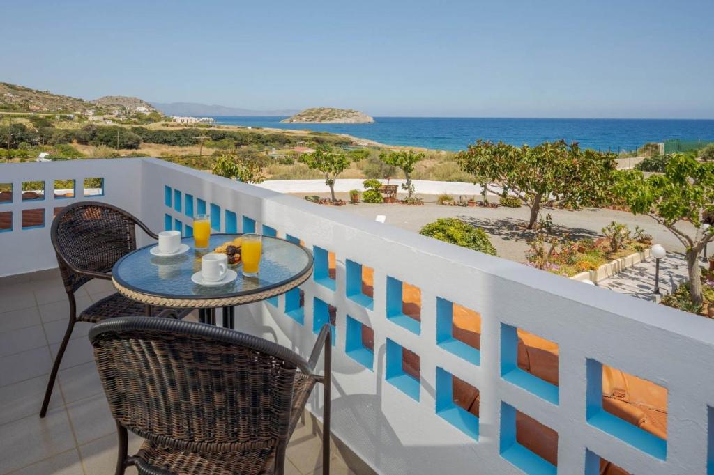 a table on a balcony with a view of the ocean at Creta Sun Mochlos in Mochlos