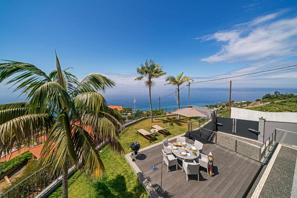 an ocean view from a house with a table and chairs at Vila Papagaio Verde by An Island Apart in Funchal