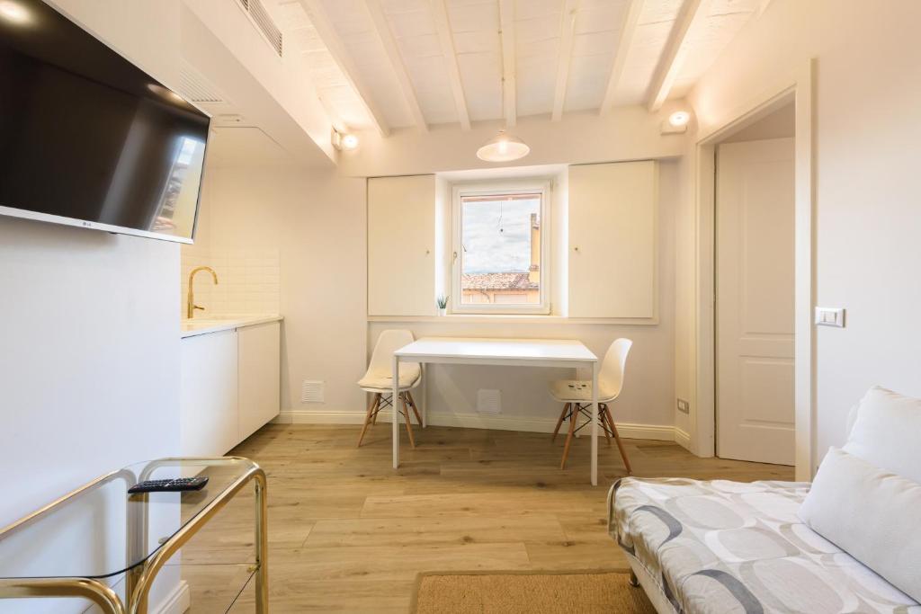 a room with a bed and a table and a window at Santa Croce Top by Mmega in Florence