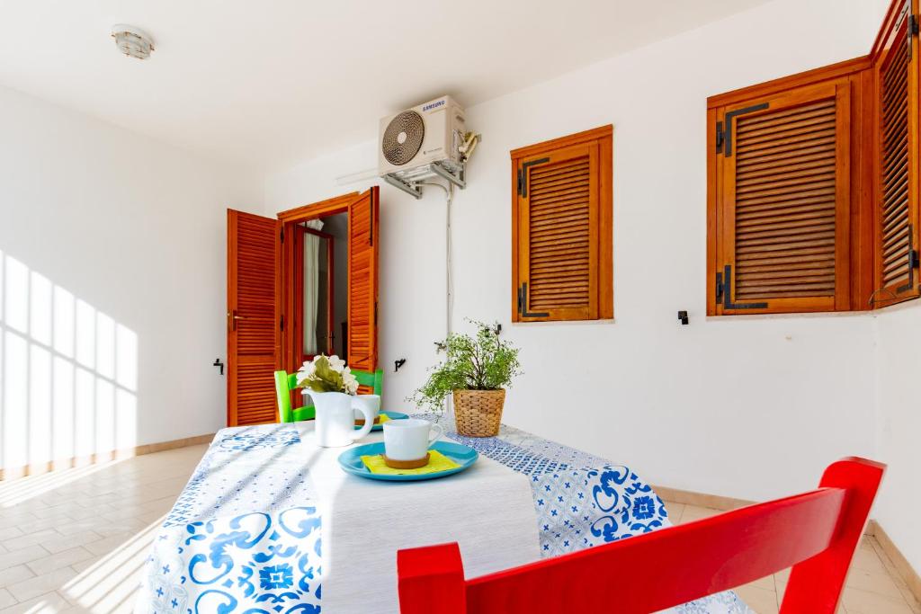 una sala da pranzo con tavolo e sedie rosse di Appartamento Anita PT - MyHo Casa a Vieste