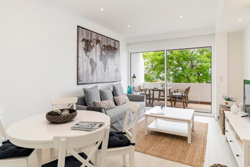 a living room with a couch and a table at Lido II by An Island Apart in Funchal