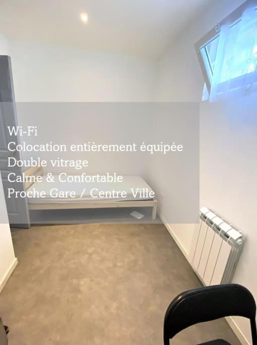a room with a chair and a sign on the wall at Adorable bedroom - Renovated in Amiens